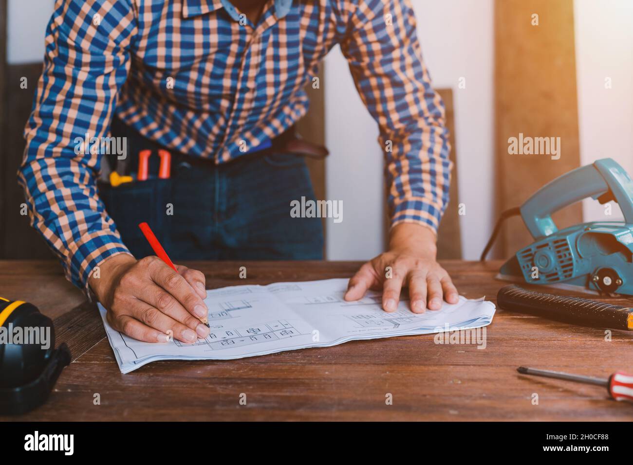 Menuisier travaillant sur les machines à travailler le bois dans l'atelier de menuiserie. Banque D'Images