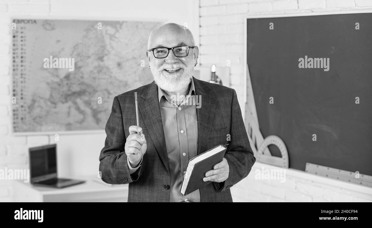 passez du temps à essayer. salle de classe avec carte et tableau noir. retour à l'école. éducation dans l'école rétro. homme barbu donner des notes dans le journal. écrire des notes dans le livre Banque D'Images