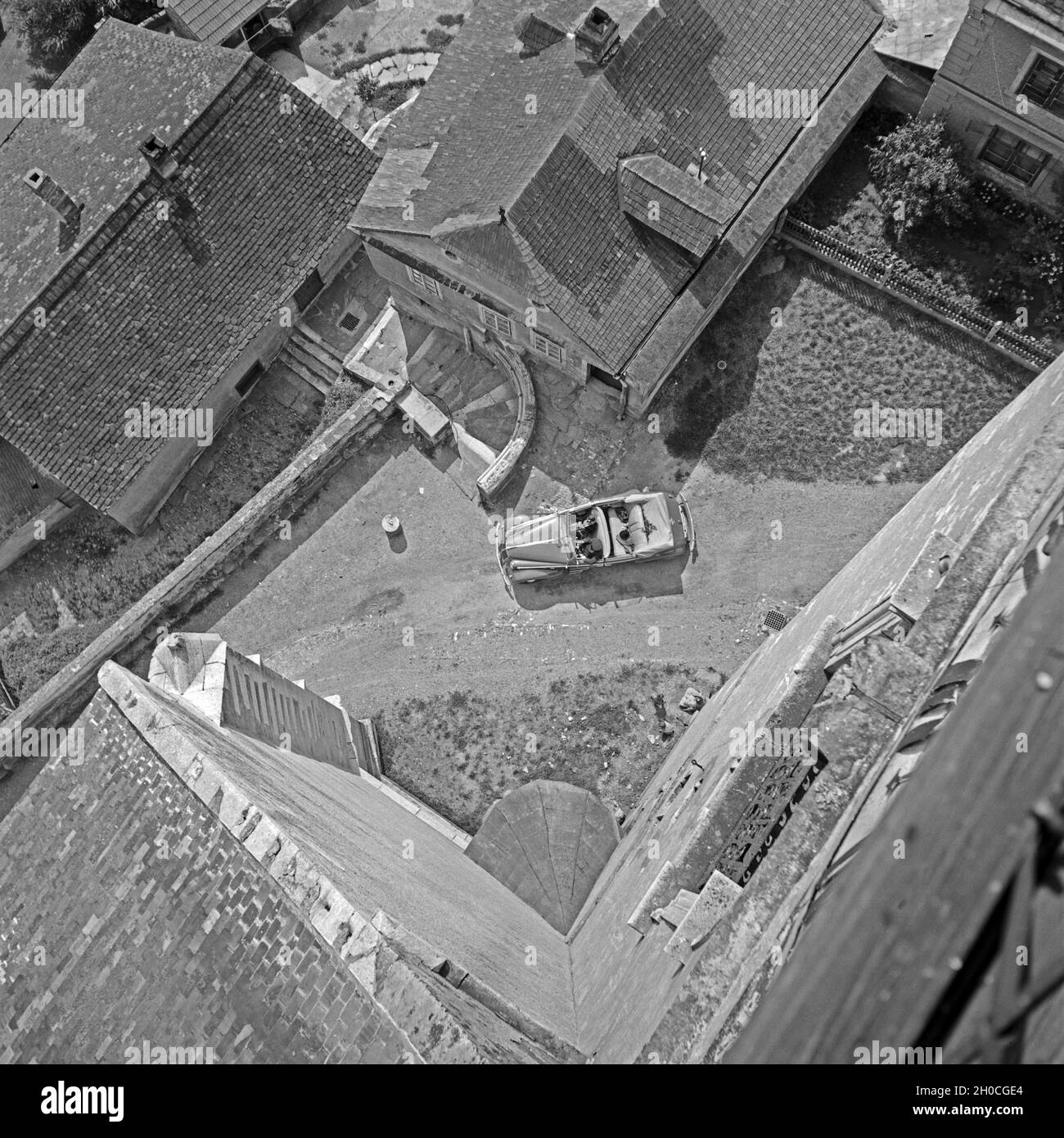Blick von einem Kirchturm auf ein durch ein Dorf fahrendes Cabrio Opel, Österreich 1930er Jahre. Vue aérienne d'un beffroi d'une Opel cabriolet, roulant dans un village, en Autriche 1930. Banque D'Images