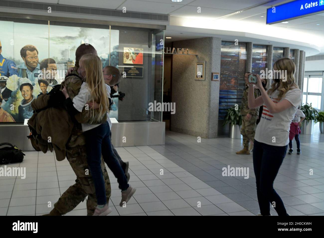 Sgt. MaîtreDave Werkema, affecté au 126e Escadron de génie civil, est accueilli par son épouse Rachel et leurs enfants, à l'aéroport international de Saint-Louis Lambert, à St. Louis (Missouri), le 23 janvier 2021.Le membre de la Garde nationale aérienne de l'Illinois est revenu d'un déploiement de six mois en Afrique. Banque D'Images