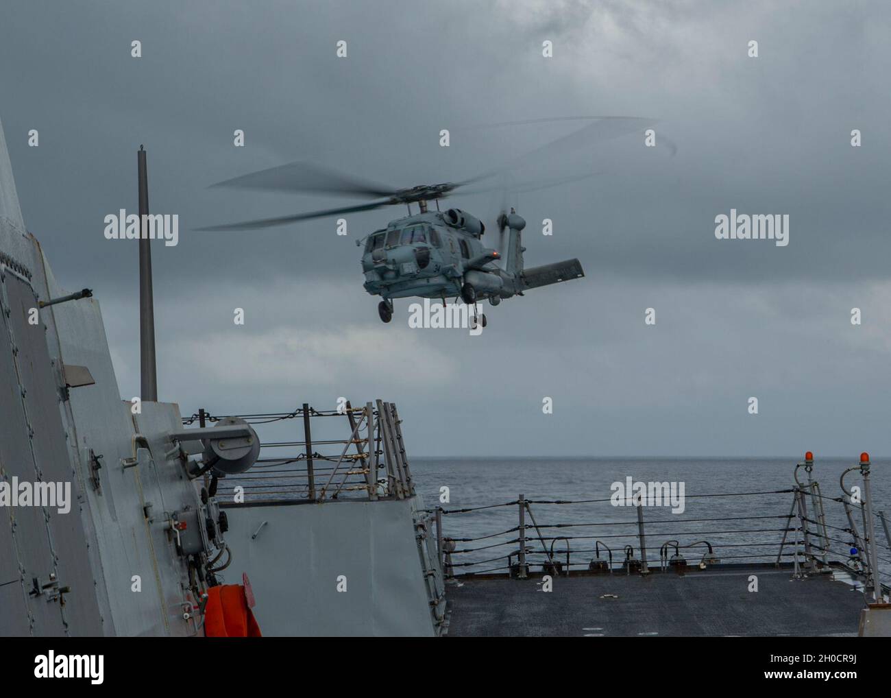 OCÉAN PACIFIQUE (janv25, 2021) un chasseur de mer MH-60R, affecté aux « magiciens » de l'escadron de frappe maritime des hélicoptères (UGV) 35, délègue le pont de vol du destroyer à missiles guidés de la classe Arleigh Burke USS John Finn (DDG 113) le 25 janvier 2021.John Finn, qui fait partie du groupe de grève des transporteurs Theodore Roosevelt, est en cours de déploiement prévu dans la zone d'exploitation de la 7e flotte américaine.En tant que plus grande flotte déployée en avant de la Marine américaine, avec environ 50-70 navires et sous-marins, 140 aéronefs et 20,000 marins dans la zone d’opérations à un moment donné, la 7e flotte effectue un déploiement en avant Banque D'Images