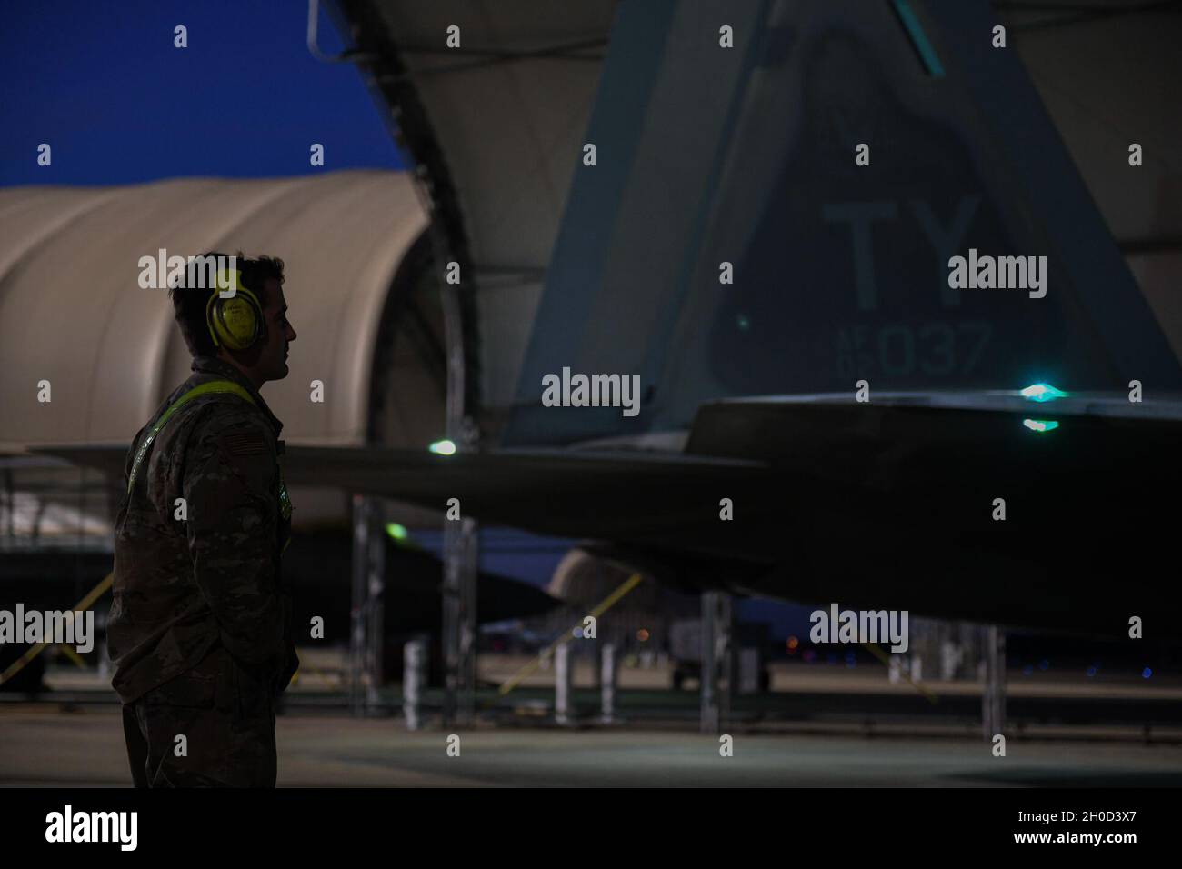 Un Airman de la US Air Force avec la 43e unité d'entretien d'aéronef se prépare à faire monter le 325e Raptor de la Fighter Wing F-22 sur la piste de la base aérienne d'Eglin, en Floride, le 28 janvier 2021.Les exercices de vol de nuit de routine permettent aux pilotes et aux équipages de rester prêts à la mission à un moment donné. Banque D'Images