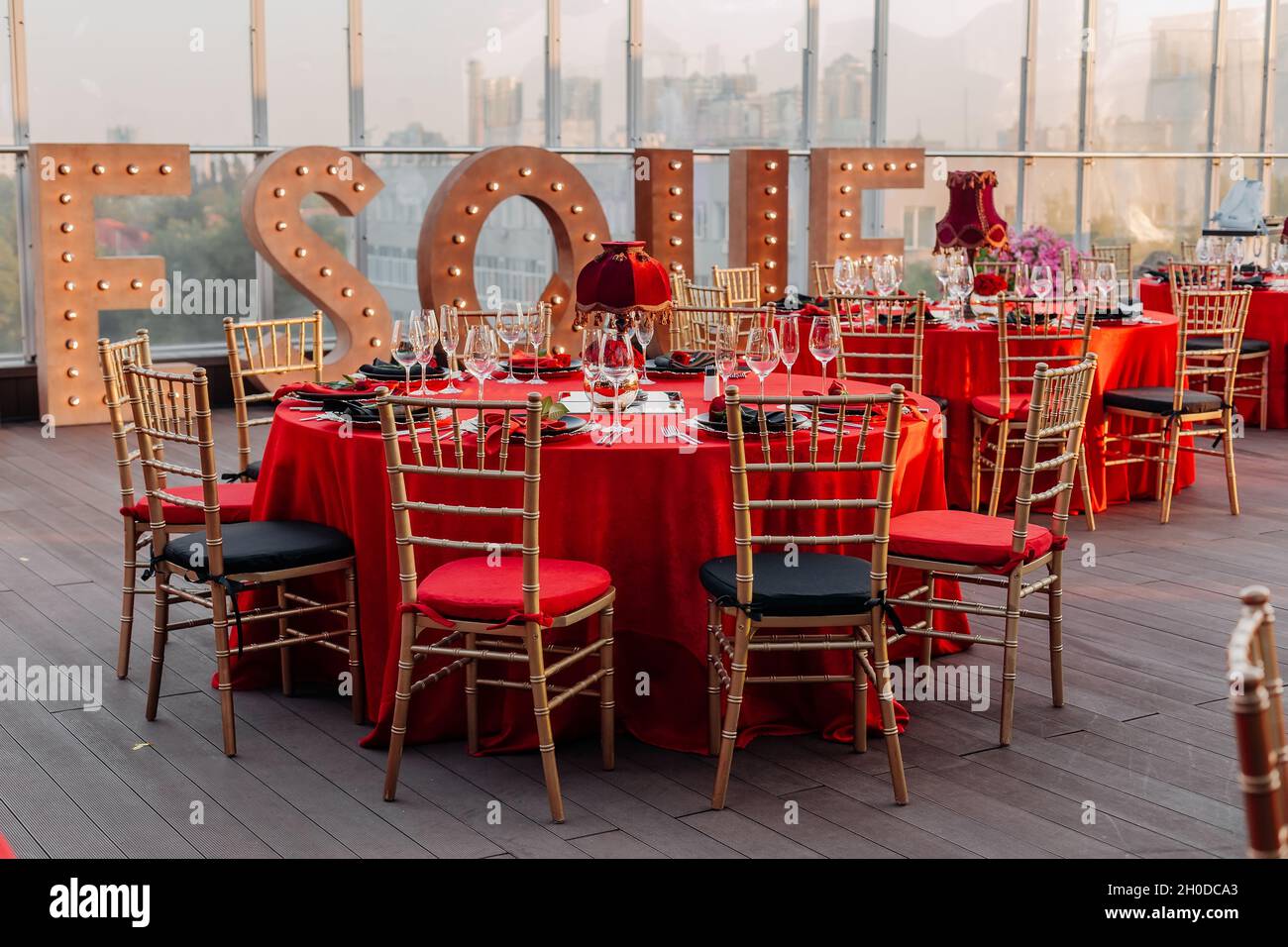 Tables et chaises pour banquet dans le style noir, rouge et or.Salle de  réception élégante : décor, nappe, assiettes, serviettes, roses,lunettes  Photo Stock - Alamy