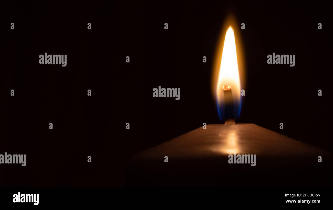 Bougie brûlante simple avec lumière douce dans l'obscurité Banque D'Images