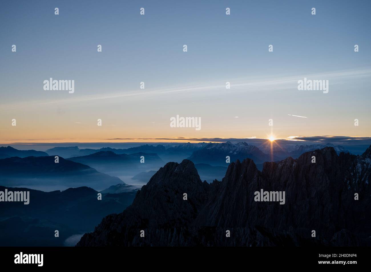 lever du soleil au sommet d'une montagne qui donne sur les sommets des alpes bavaroises et autrichiennes avec brouillard dans les vallées Banque D'Images