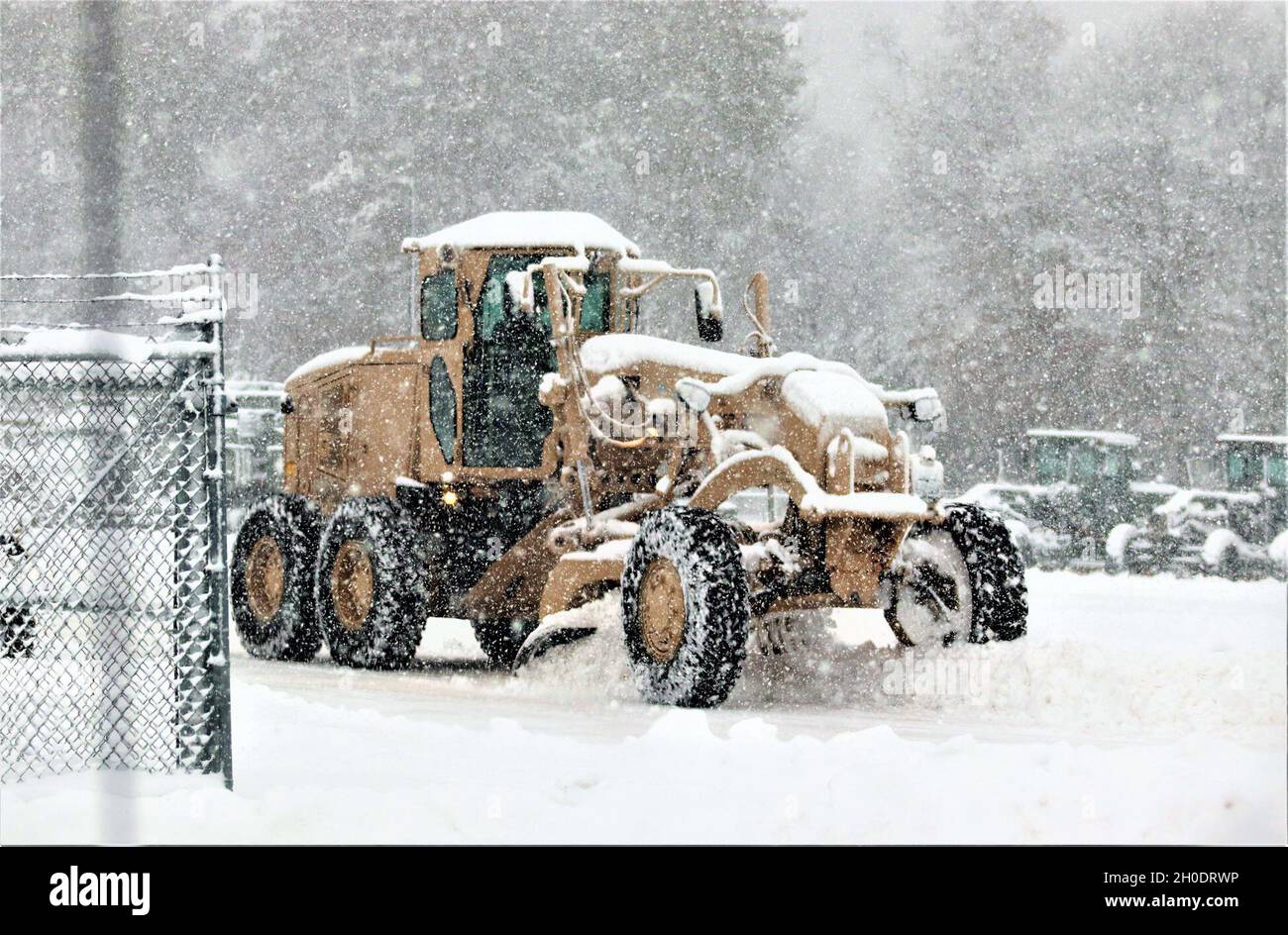 Un membre du personnel du site régional d’entraînement – entretien conduit un niveleur pour déplacer la neige à mesure que la neige abondante tombe le 4 février 2021, à fort McCoy, dans le Wisconsin. RTS – entretien forme des centaines de soldats chaque année dans le MOS de la série 91 de l’Armée de terre et soutient administrativement l’entraînement des soldats dans le MOS 89B.L'unité s'aligne sous la 3e Brigade (Ordnance), la 94e Division du 80e Commandement de l'entraînement, et est située au centre de la zone du cantonnement avec un complexe entier pour l'entraînement. Banque D'Images