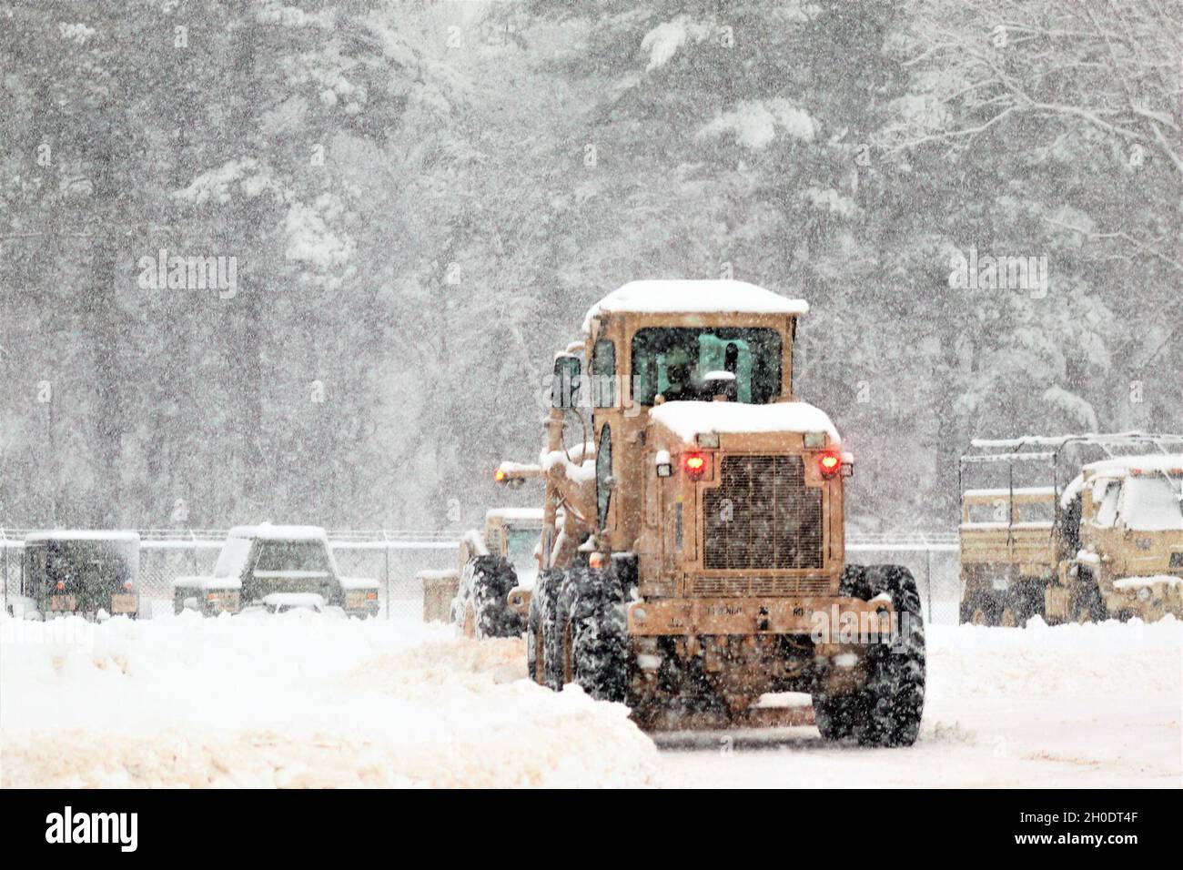 Un membre du personnel du site régional d’entraînement – entretien conduit un niveleur pour déplacer la neige à mesure que la neige abondante tombe le 4 février 2021, à fort McCoy, dans le Wisconsin. RTS – entretien forme des centaines de soldats chaque année dans le MOS de la série 91 de l’Armée de terre et soutient administrativement l’entraînement des soldats dans le MOS 89B.L'unité s'aligne sous la 3e Brigade (Ordnance), la 94e Division du 80e Commandement de l'entraînement, et est située au centre de la zone du cantonnement avec un complexe entier pour l'entraînement. Banque D'Images