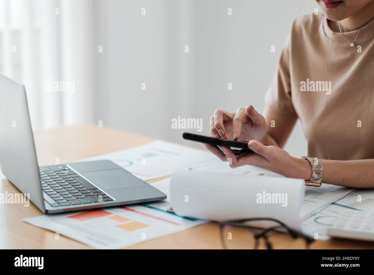 Gros plan les jeunes femmes travaillent avec des documents financiers à la maison comptent sur la calculatrice avant de payer les recettes fiscales en ligne par téléphone Banque D'Images