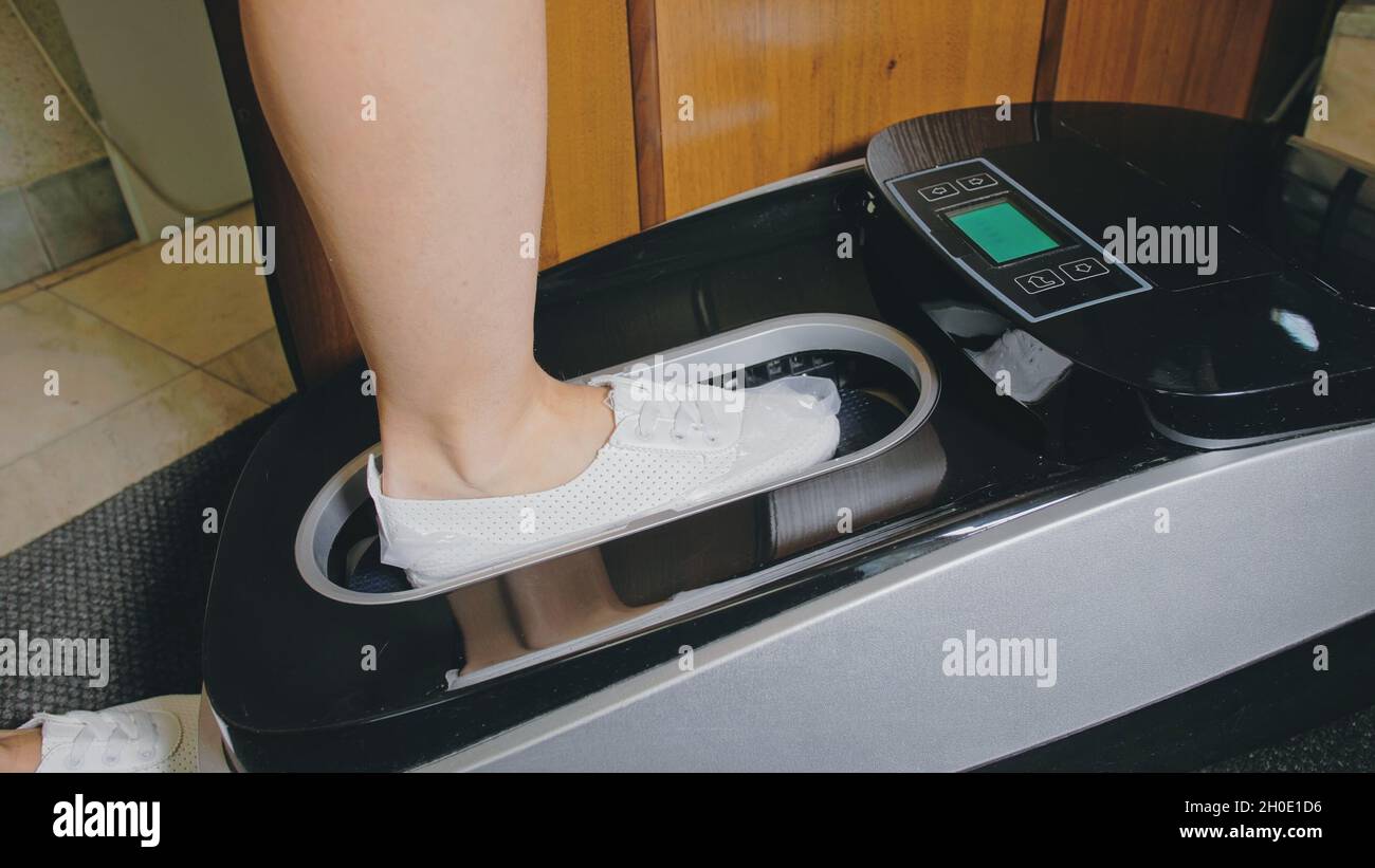 Machine à plastifier le couvre-chaussures thermorétractable  automatique.Gros plan.La machine applique automatiquement des surchaussures  aux chaussures du patient Photo Stock - Alamy