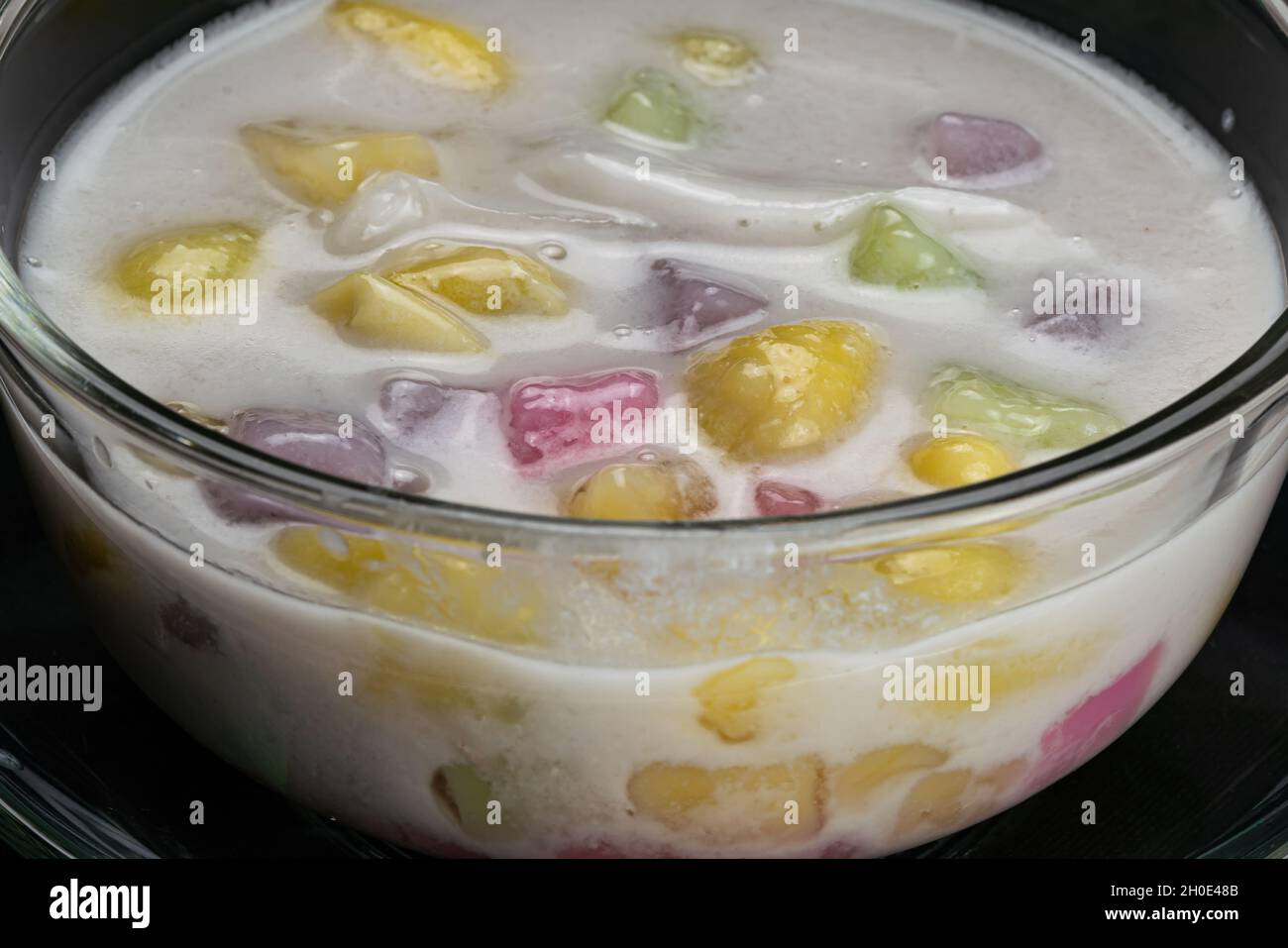 Vue en grand angle de délicieux desserts maison boules de riz collant, fruits de ginkgo et viande de noix de coco dans le lait de coco doux dans un bol transparent.Dessicateur thaïlandais Banque D'Images