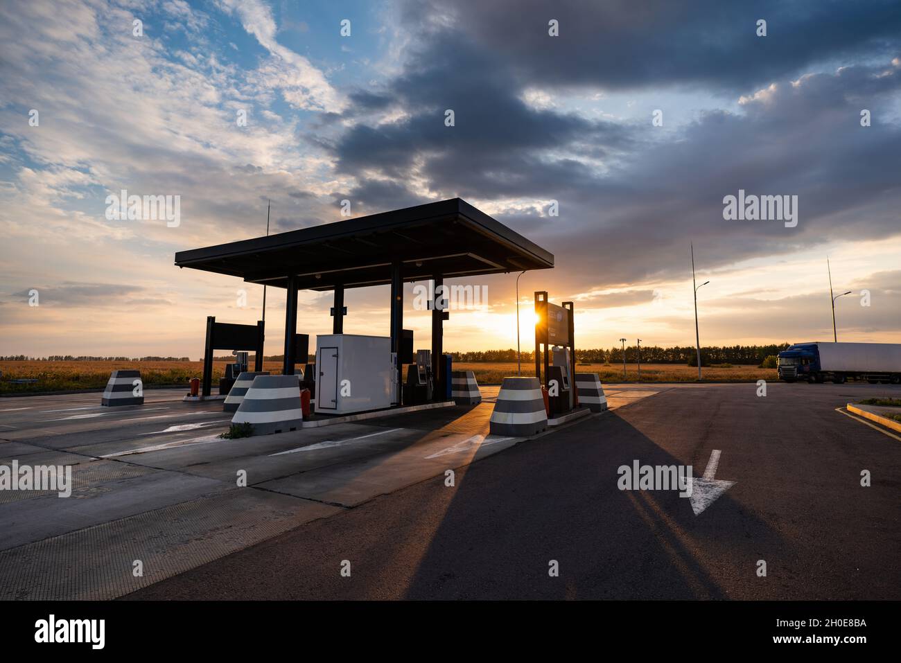 Station-service moderne en libre-service sur fond de ciel spectaculaire au coucher du soleil Banque D'Images