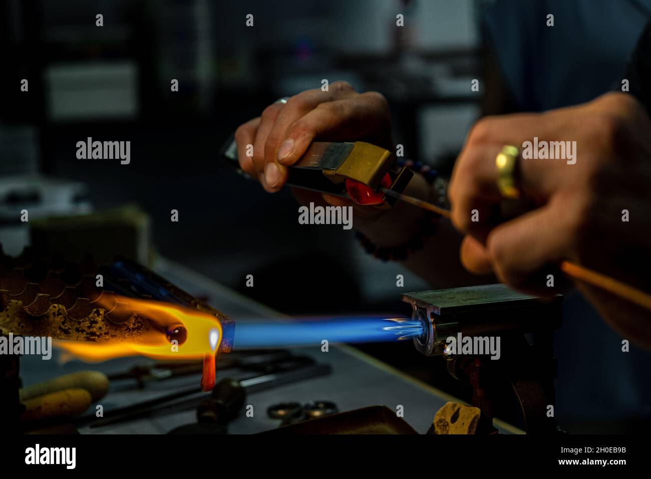 Les mains d'un ouvrier de feu pendant la fabrication de perles de verre. Cet art a été inscrit en 2020 sur la liste représentative du patrimoine culturel immatériel Banque D'Images