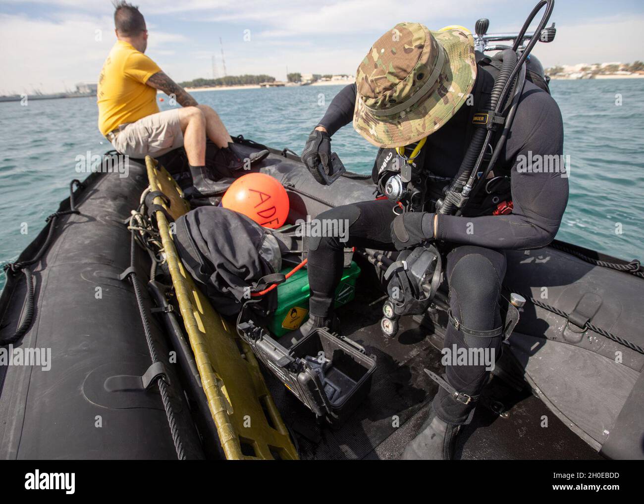 Plongeur en chef Sgt.Daniel Sivori, 74th Engineer Dive Detachment, ajoute du poids à son compensateur de flottabilité lors d'un engagement à la base navale du Koweït, le 10 février 2021.Sivori a déclaré que les plongeurs utilisent des poids pour aider le plongeur à contrer la flottabilité de la combinaison humide.Cela permet au plongeur de descendre plus facilement dans la colonne d'eau. Banque D'Images