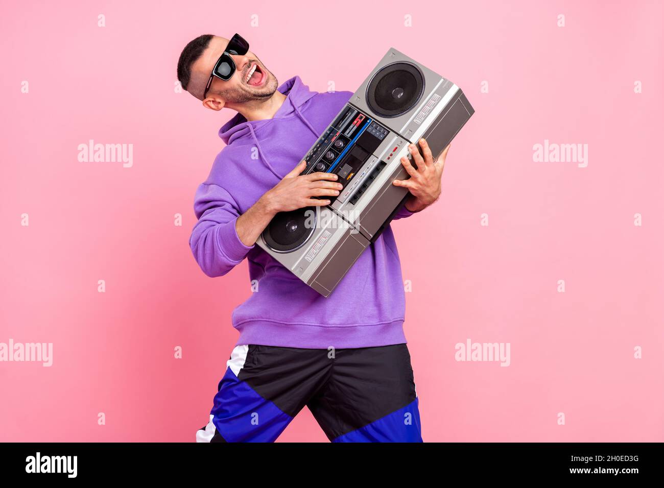 Photo du jeune garçon cool brunet boom box porter des lunettes pull à  capuche isolé sur fond rose Photo Stock - Alamy