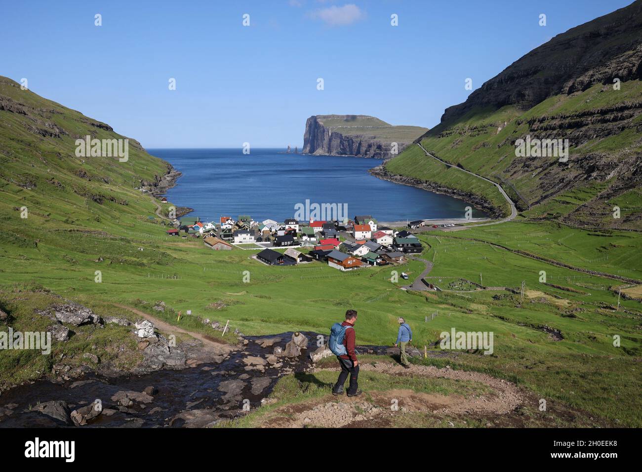 Randonneurs marchant sur une colline vers le village de Tjornuvik, l'île de Streymoy, les îles Féroé, la Scandinavie, l'Europe Banque D'Images