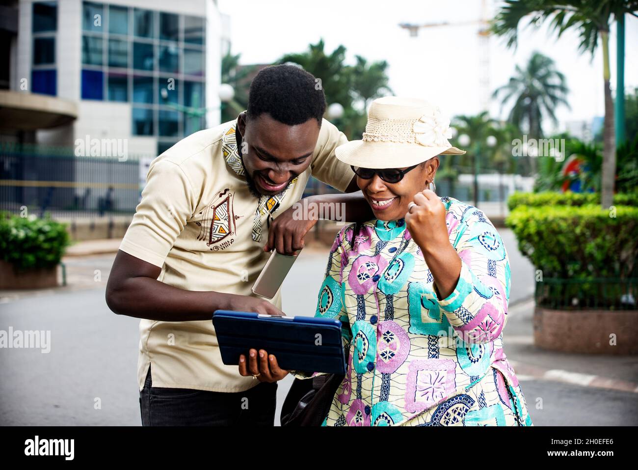 Couple heureux de passer un appel vidéo et souriant debout dans la rue.Couple élégant amoureux de prendre des photos de selfie et de s'amuser.Voyagez ensemble et portez-vous Banque D'Images