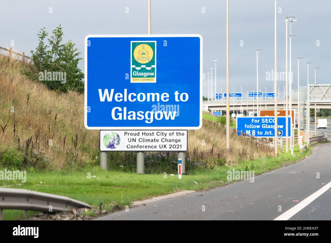 Glasgow, Écosse, Royaume-Uni.12 octobre 2021.Bienvenue à Glasgow « Proud Host City of the ONU Climate change Conference UK 2021 », panneau à côté de l'autoroute M8, la Coalition COP26 partageant un appel de Human Hotel pour que les habitants de Glasgow deviennent des hôtes Homestay et aident les autres combattants pour l'action climatique à Glasgow Credit: Kay Roxby/Alay Live News Banque D'Images