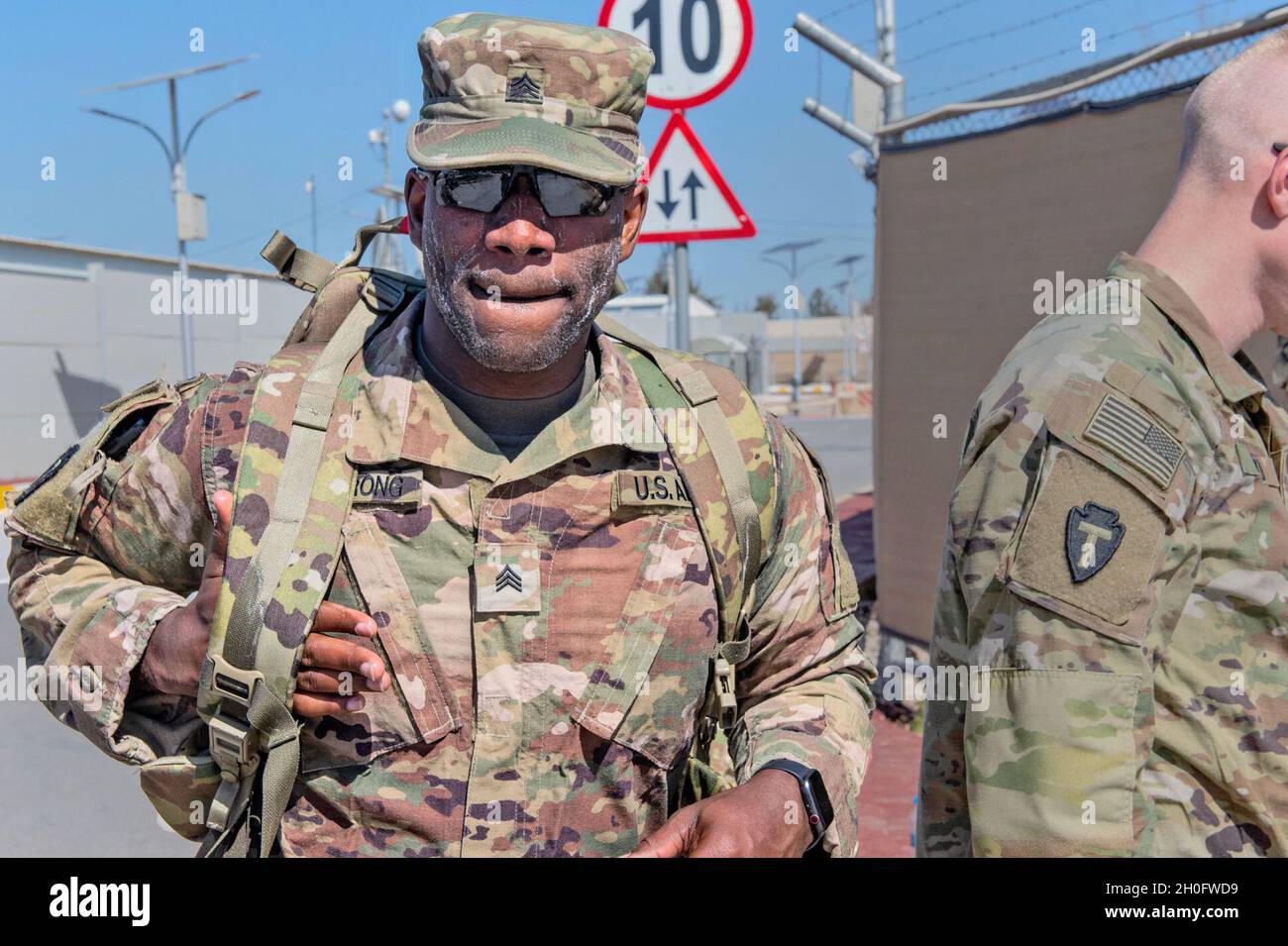Sgt.Lamar Armstrong, avec la garde nationale du Texas, déployé au  Moyen-Orient pour soutenir la Force opérationnelle Spartan, commence à se  retirer de son sac à dos après avoir gagné l'insigne de marche