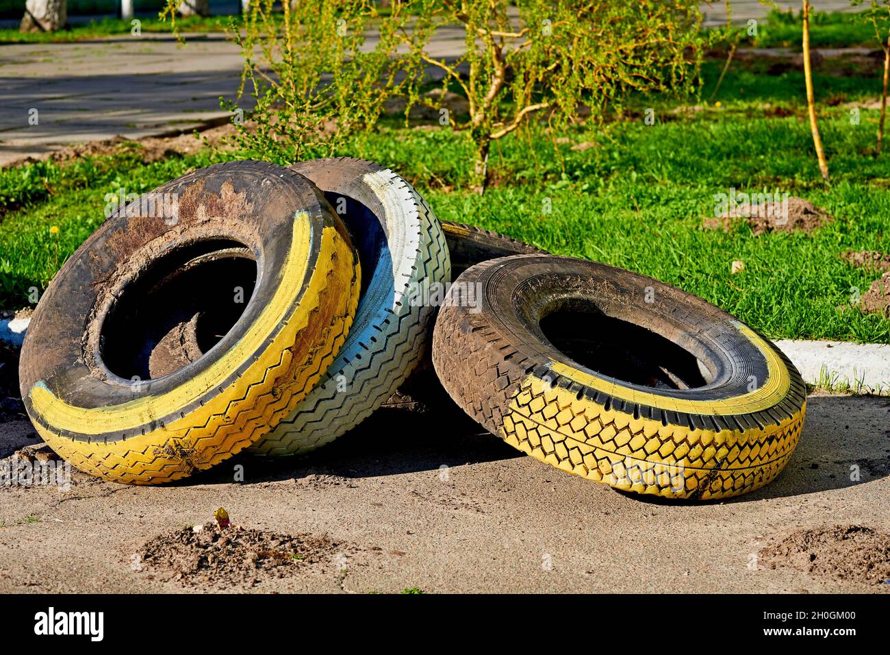 Trois vieux pneus peints sur une pelouse verte Banque D'Images