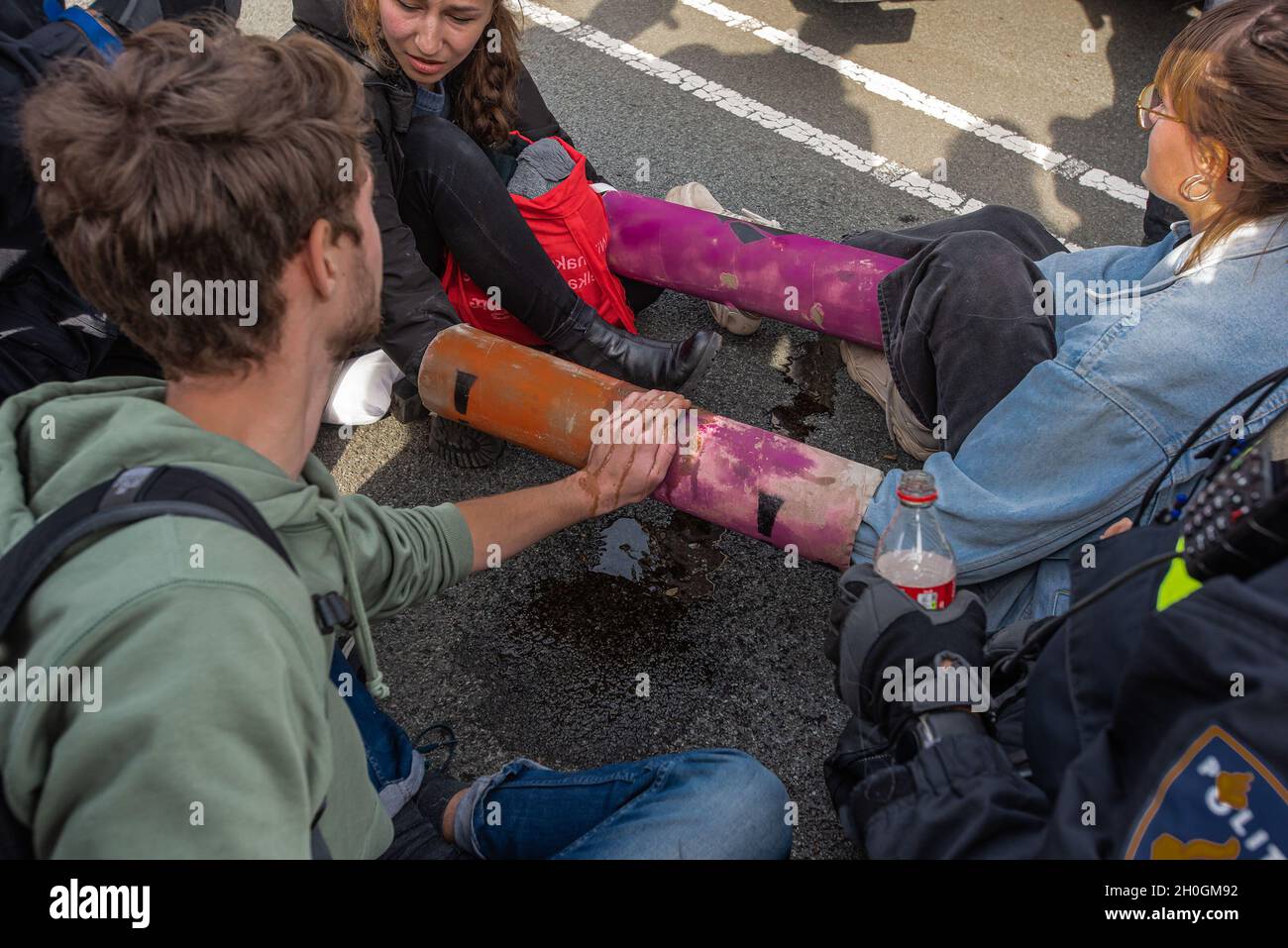 Les militants sont vus avec les mains enfermées dans un tube de ciment et avec les mains surcollées, alors que la police tente des libérer lors de la manifestation sur le climat à la Haye.la rébellion contre l'extinction (ER) a organisé une importante manifestation sur le climat à la Haye, qui a impliqué environ 200 à 300 activistes sur le climat.L'ER prévoit d'organiser des manifestations pour les sept prochains jours, certaines annoncées à l'avance et d'autres non, y compris le blocage de l'intersection entre la Chambre temporaire des représentants et le ministère des Affaires économiques et du climat.L'action est une semaine avant une grande conférence des Nations Unies sur le climat, 'sommet COP26 à Glasgow, S. Banque D'Images