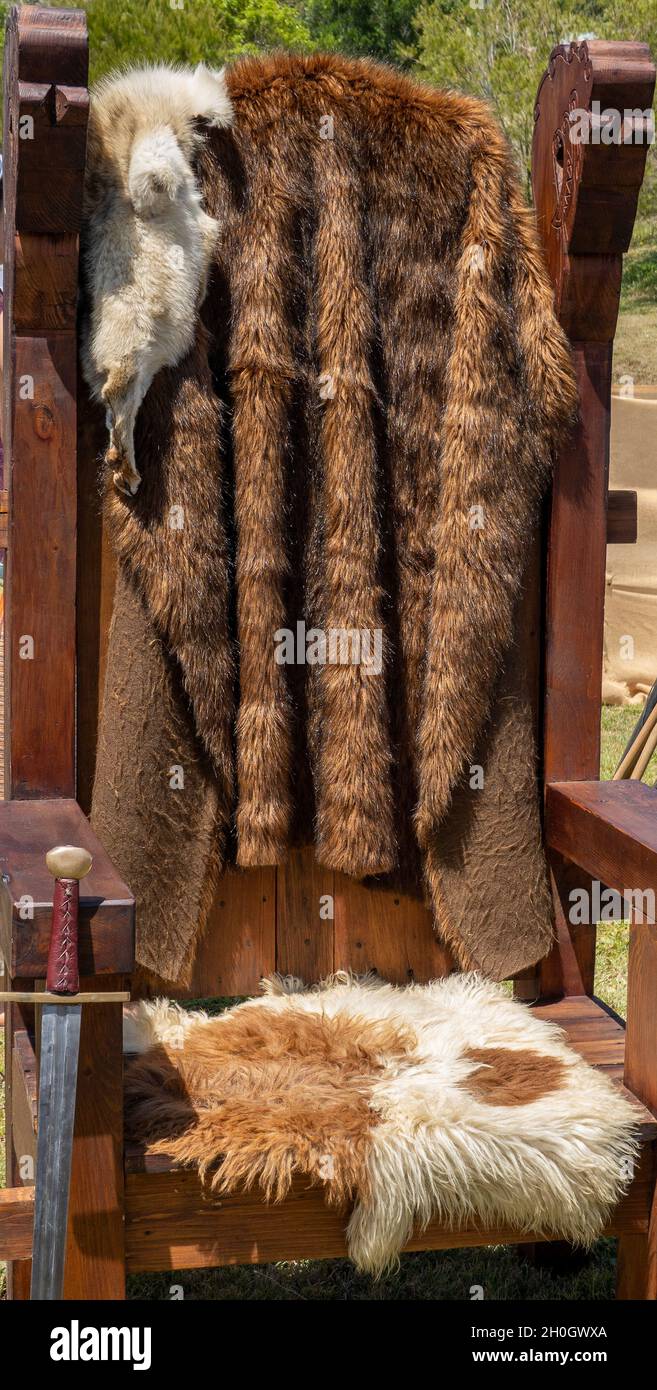 Une réplique de chaise viking en bois recouverte de fourrures et d'une épée  à une foire du village de troupe reconstituée Photo Stock - Alamy