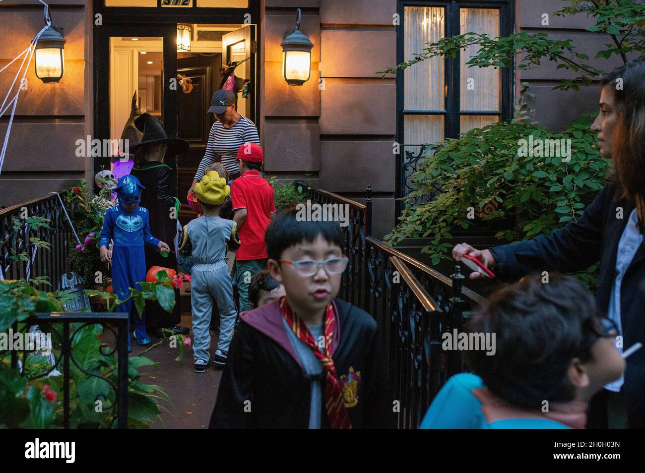 Une femme qui donne des bonbons à trick ou des Treators pour Halloween à New York. Banque D'Images