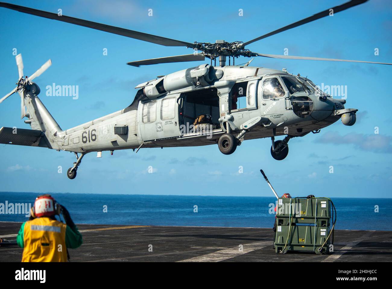 211011-N-DW158-1015 OCÉAN PACIFIQUE (OCT11, 2021) un Faucon de mer MH-60S, attaché aux faucons d'or de l'Escadron de combat de la mer (HSC) 12, ramasse des marchandises du pont de vol du seul porte-avions déployé par l'avant de la Marine américaine USS Ronald Reagan (CVN 76), au cours d'un réapprovisionnement vertical.Ronald Reagan, le navire amiral du Carrier Strike Group 5, fournit une force prête à combattre qui protège et défend les États-Unis, et soutient les alliances, les partenariats et les intérêts maritimes collectifs dans la région Indo-Pacifique.(É.-U.Photo de la marine par Spécialiste des communications de masse 3e classe Gray Gibson Banque D'Images
