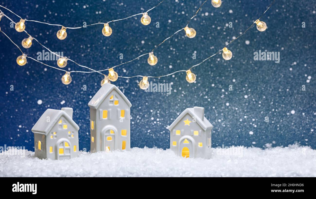 décorations de noël avec maisons de jouets illuminées et guirlande lumineuse sur fond bleu Banque D'Images