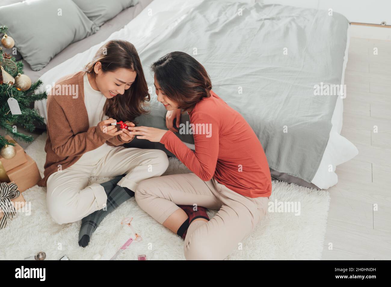 deux magnifiques jeunes femmes asiatiques peignent des ongles allant des pédicures, l'un d'eux souffle sur les ongles Banque D'Images