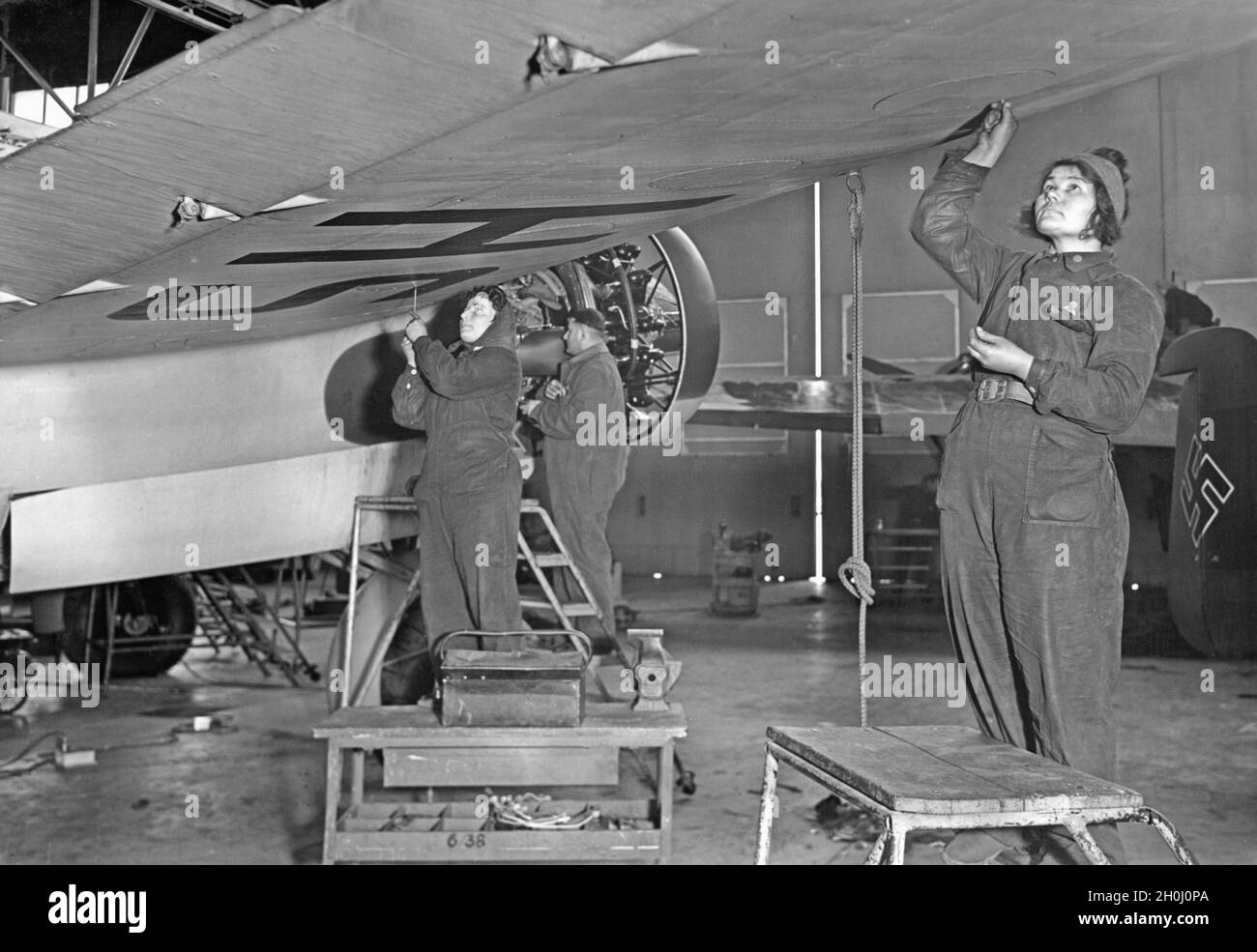 Les femmes d'une usine d'armement allemande effectuent le travail final sur un avion avant du transmettre aux opérations de vol.[traduction automatique] Banque D'Images
