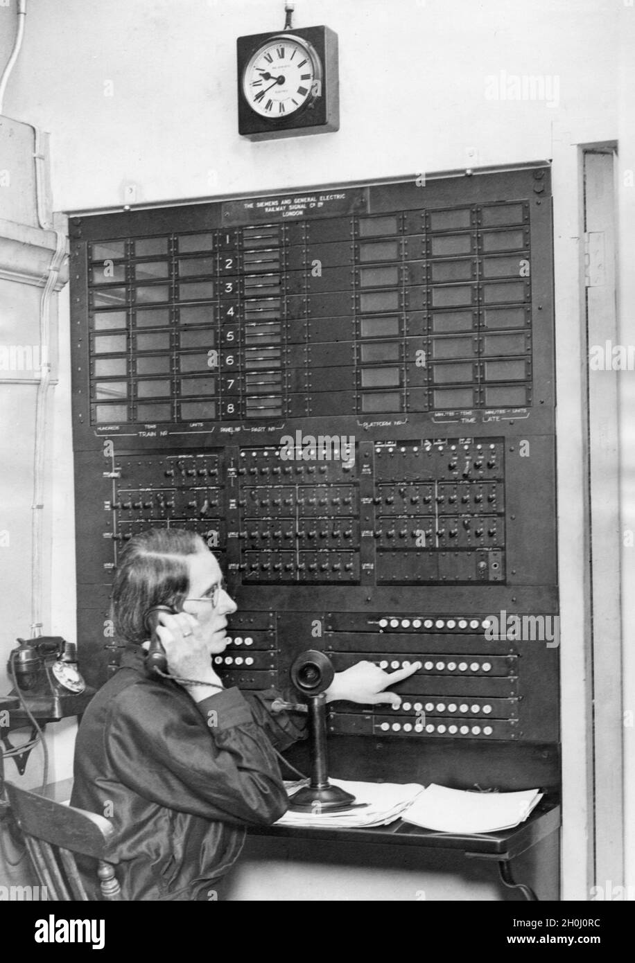 Un membre du personnel du centre de contrôle de la gare de Paddington informe les passagers des horaires et des voies d'arrivée et de départ des trains.[traduction automatique] Banque D'Images