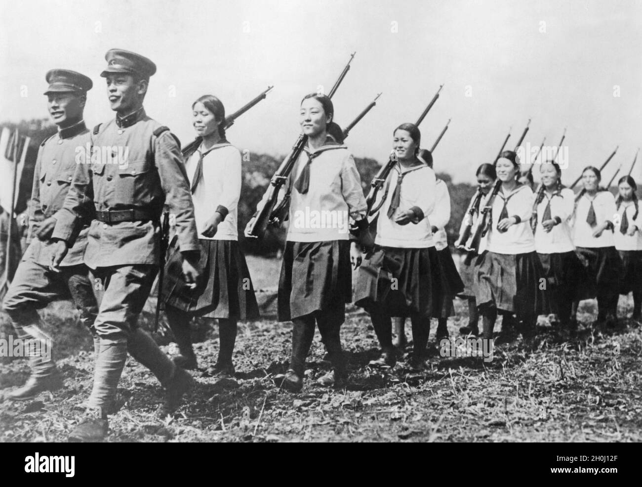 Les écoliers de différentes écoles de Tokyo ont un aperçu de l'entraînement militaire de base lors d'une visite au 3e Régiment d'infanterie : les filles forent avec des fusils sur leurs épaules.(photo non datée) [traduction automatique] Banque D'Images