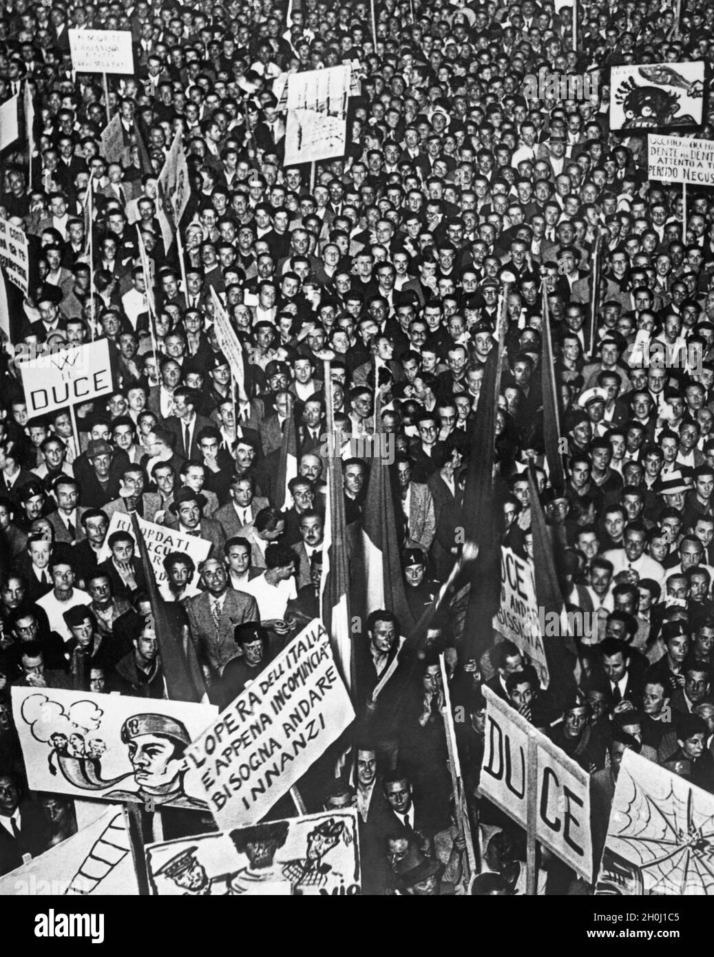 'Lors d'un rassemblement de masse à Rome en 1936, la foule a tenu des affiches avec des dessins animés diffamant l'Angleterre, le Japon, la Turquie et l'Inde (premier plan).Le rassemblement a été provoqué par la question abyssinienne et la guerre d'agression italienne contre l'Éthiopie.Les signes sont les suivants : ''l'opéra dell'Italia / e appena incominciata / bisogna andare / innanzi'', ''VV [Viva] il Duce'', ''Occhio per occhio / dente per dente / attento a te / perfido Necus''.[traduction automatique]' Banque D'Images