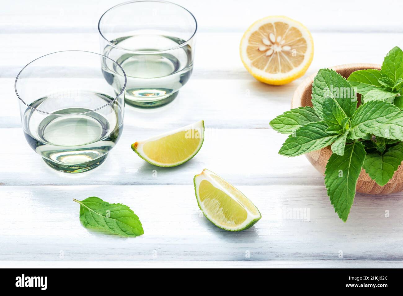 Ingrédients pour faire les mojitos de feuilles de menthe, citron vert, citron et vodka sur fond rustique. Banque D'Images