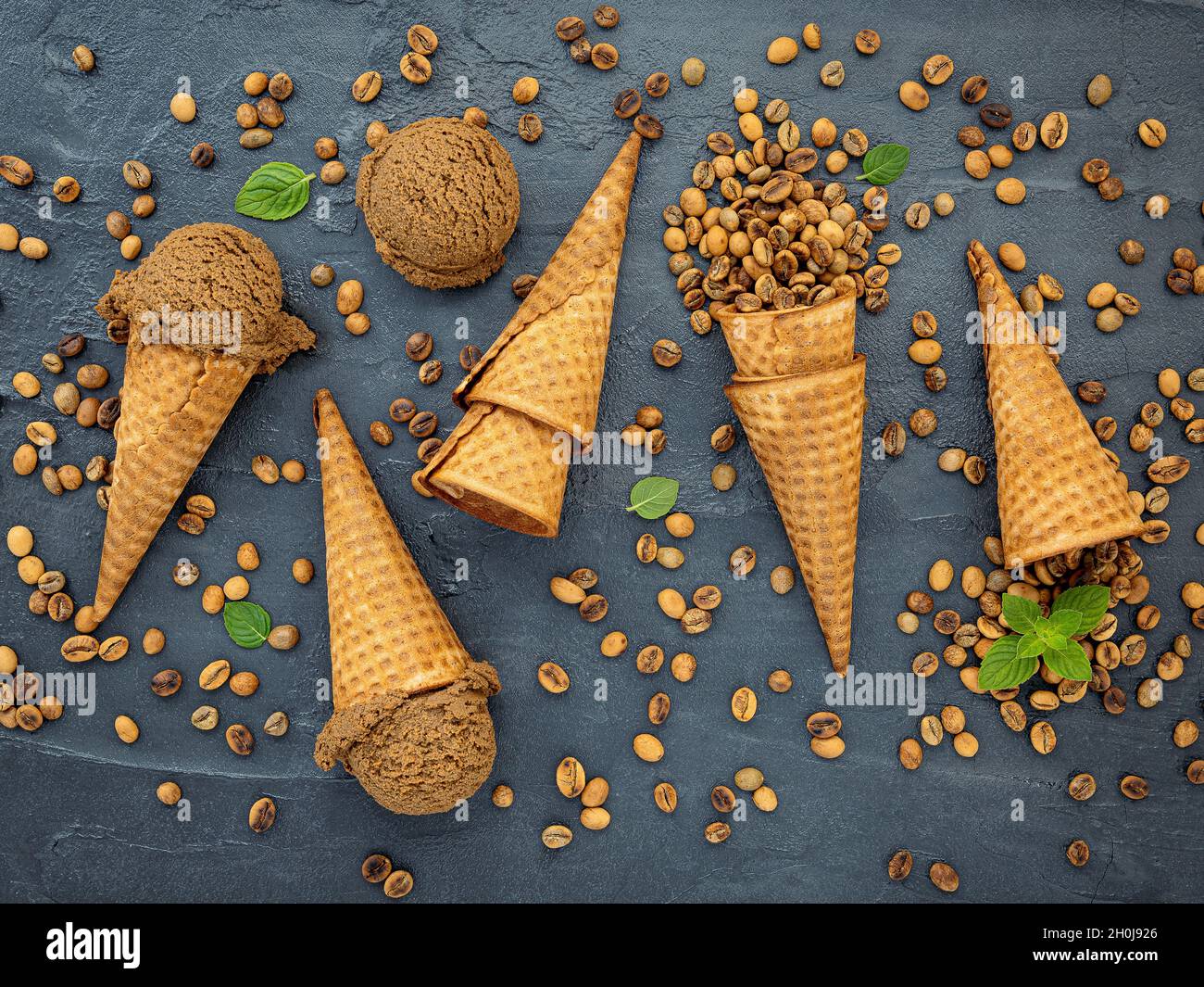 Plat déposer la crème glacée au café dans le cône gaufré sur fond de pierre sombre . Crème glacée au café maison avec grains de café pour créer un menu de bonbons. Banque D'Images