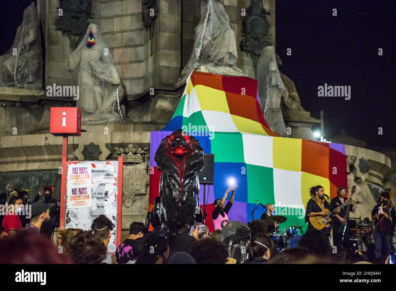 Barcelone, Catalogne, Espagne.12 octobre 2021.La statue du lion du monument de Christophe Colomb est visible sous la peinture rouge devant un drapeau de Wiphala.divers groupes anticolonialistes ont appelé une manifestation qui a quitté les Ramblas de Barcelone jusqu'à la statue de Christophe Colomb, avec les slogans ''ils ne nous conquéront pas'' et ''rien à célébrer'.Les groupes ont protesté contre la célébration du 12 octobre, jour hispanique.Diverses présentations culturelles et représentations de peuples autochtones de pays d'Amérique latine et d'Afrique ont été réalisées.(Credit image: © Thiago Prudencio/DAX vi Banque D'Images