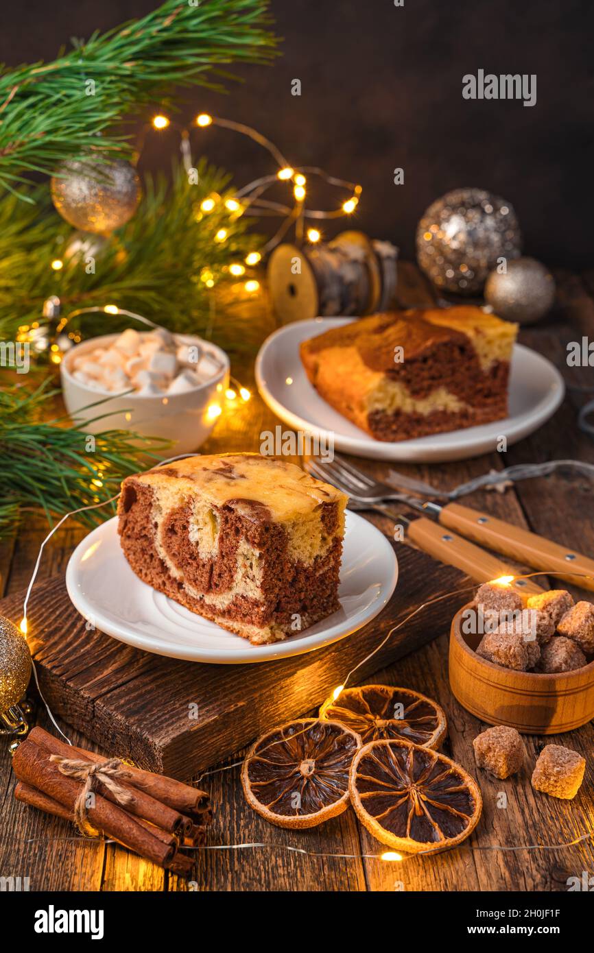 Un morceau de tarte zébrée sur un fond de Noël avec des lumières allumées. Banque D'Images