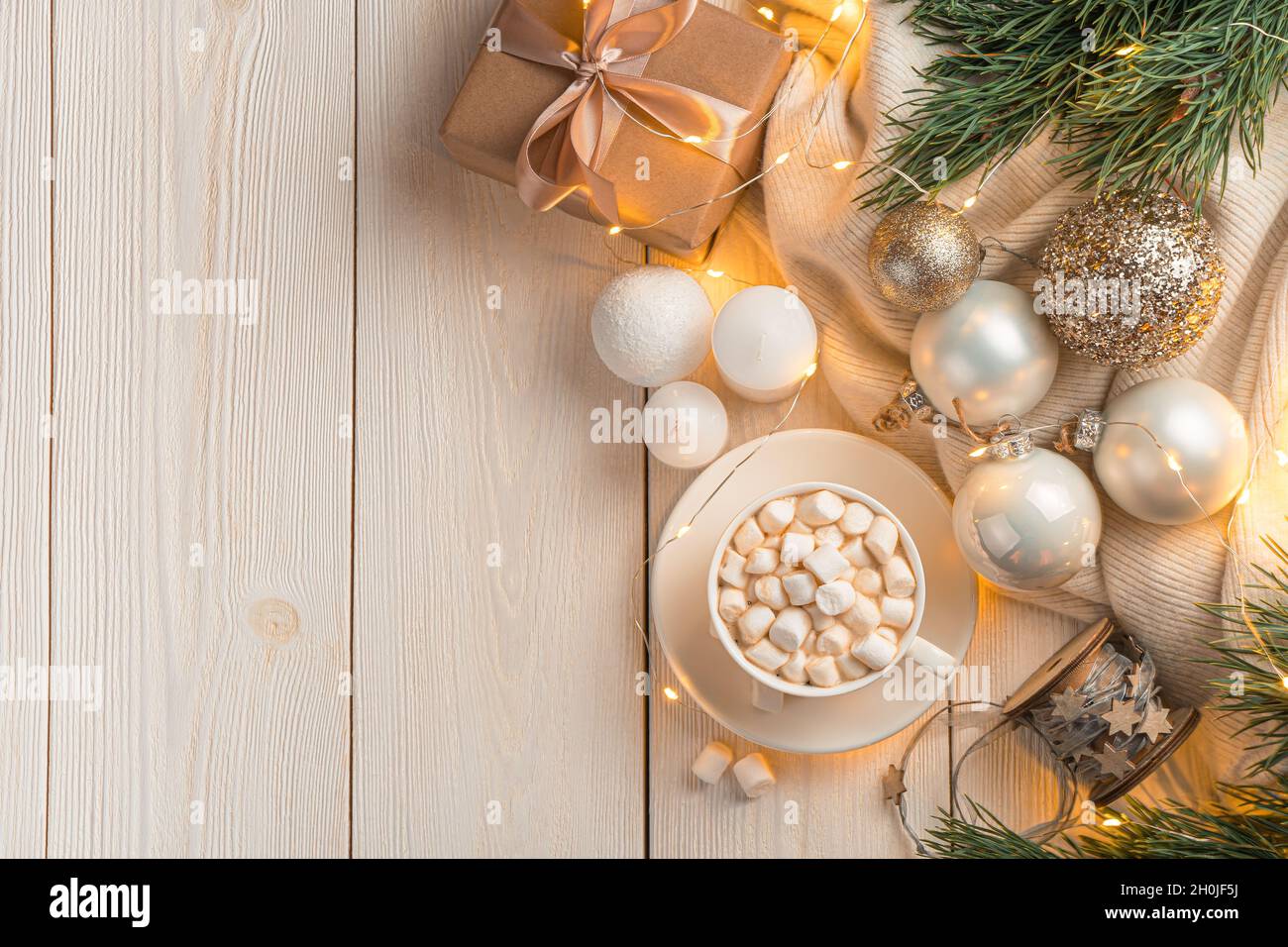 Ambiance de Noël avec une tasse de café et des décorations de Noël sur un fond clair à la lumière des lumières allumées. Banque D'Images