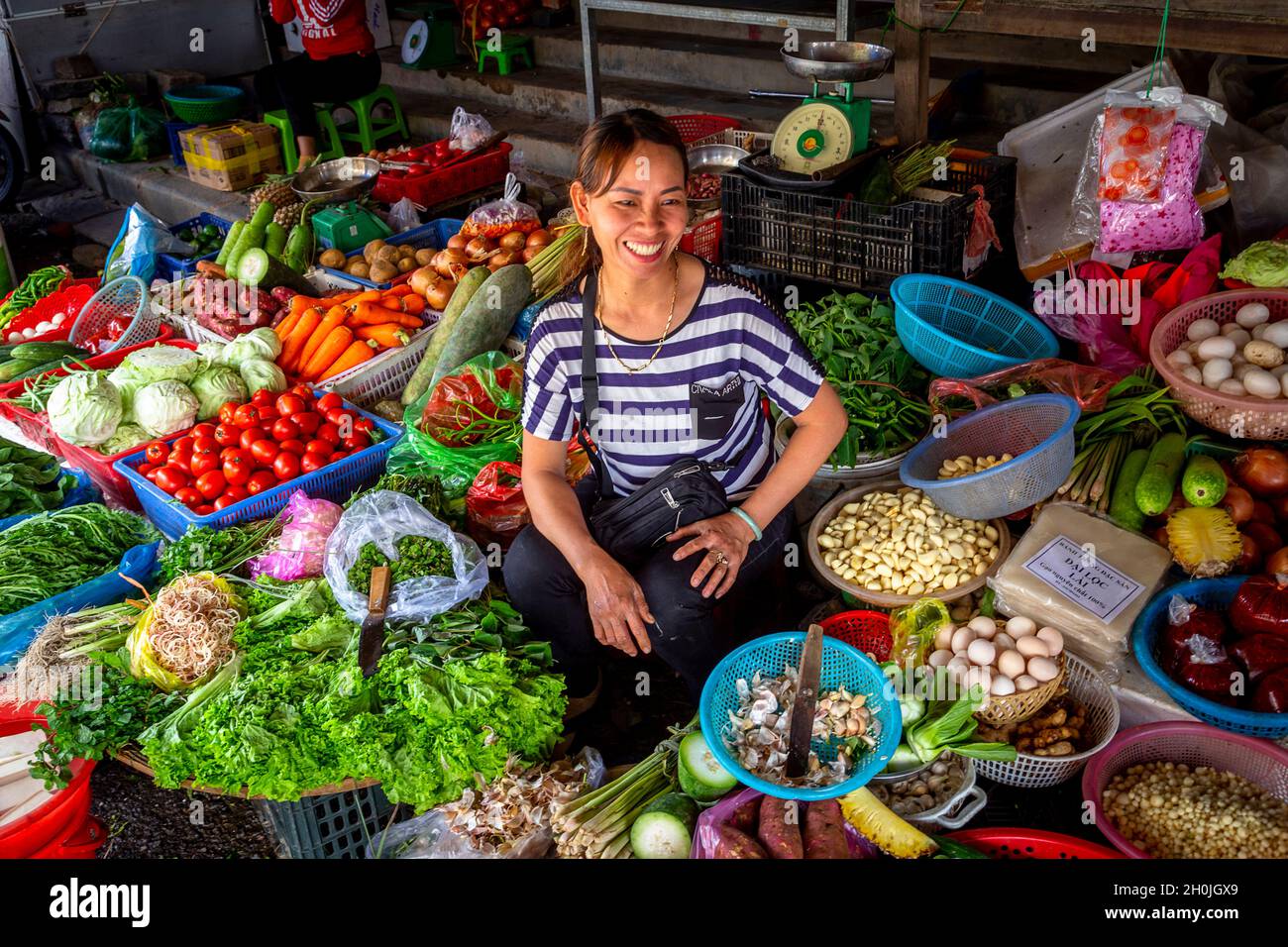 Une dame vietnamienne sourit de travailler à la vente de produits au marché de Hoi an. Banque D'Images