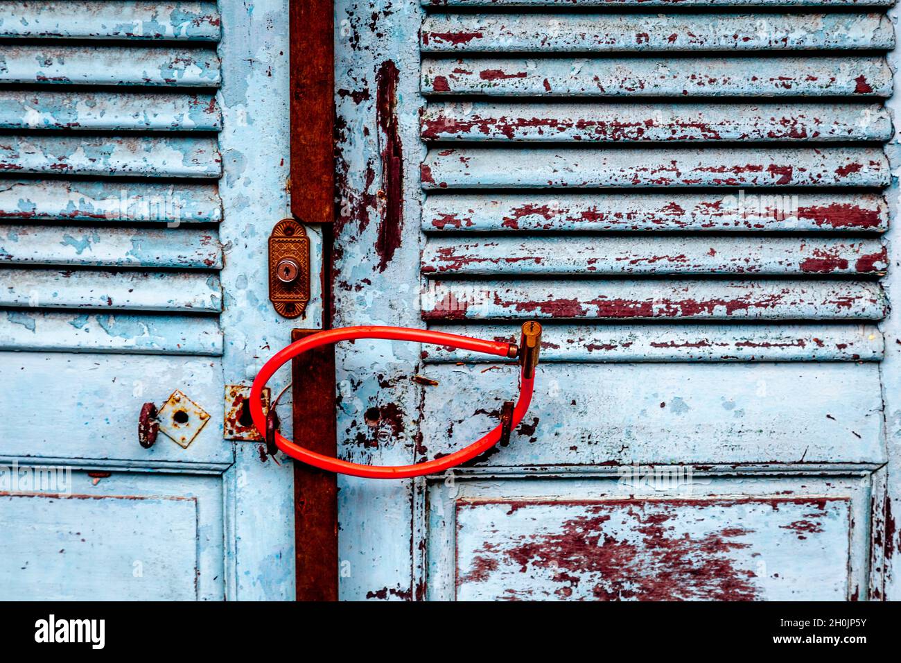 Un câble rouge verrouille deux portes ensemble dans la vieille ville de Hoi an pendant Covid-19. Banque D'Images