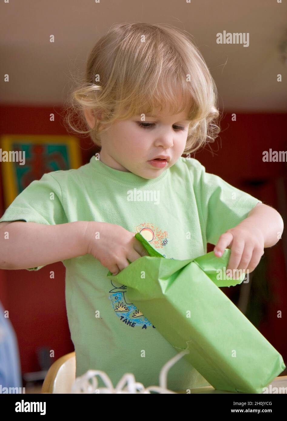 fête d'anniversaire des enfants, petite fille déballant ses cadeaux d'anniversaire Banque D'Images