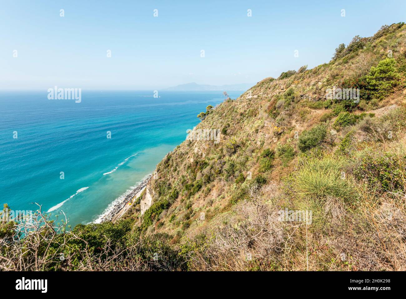 Paysage avec le shrubland méditerranéen sur la pente raide de la côte de Tigullio face à la mer bleue, tourné dans la lumière d'automne près de Cavi, Tigullio, Genova, Liguri Banque D'Images