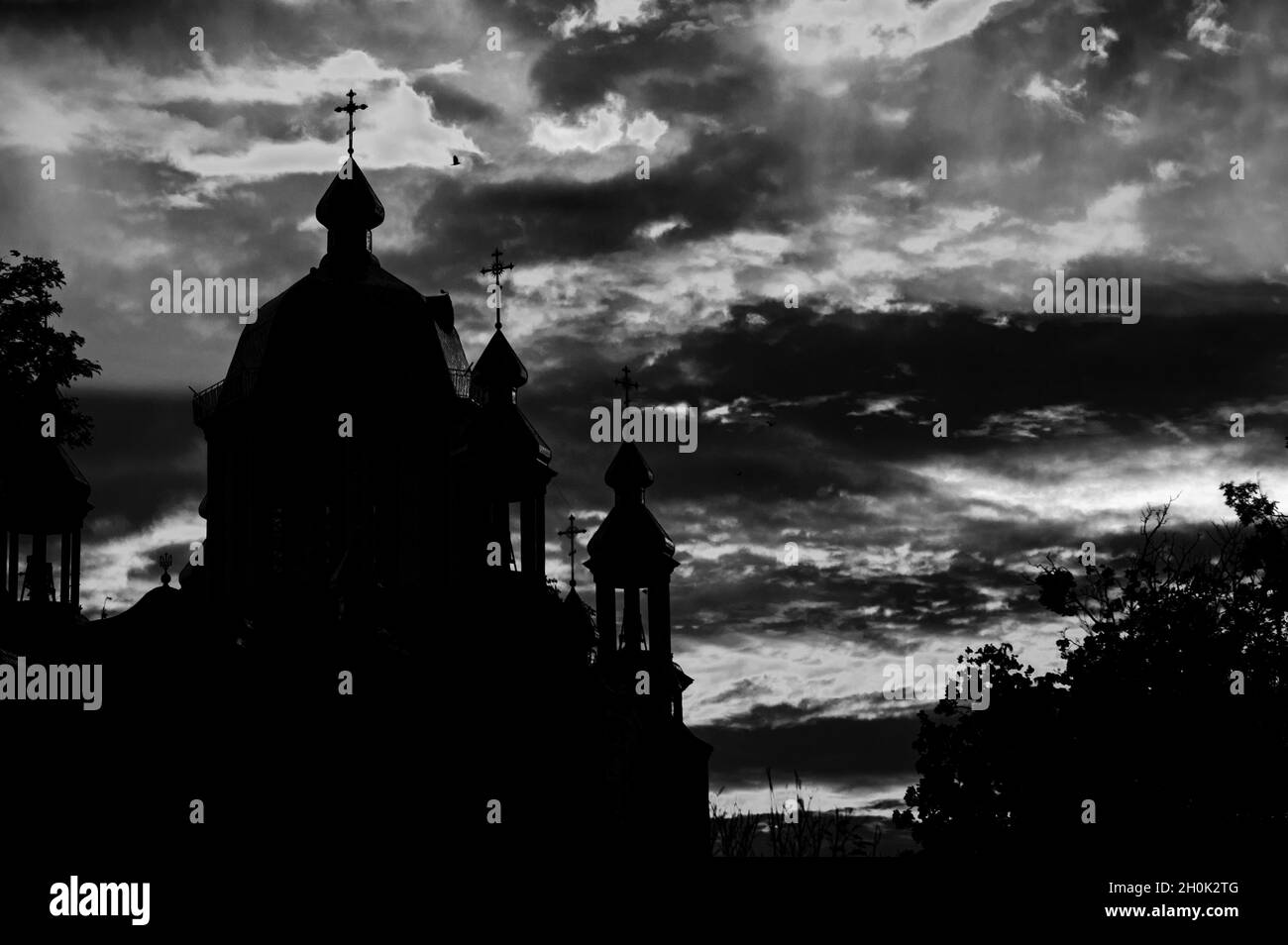 Édifice religieux silhoueté.Ciel rouge majestueux.Image en noir et blanc Banque D'Images