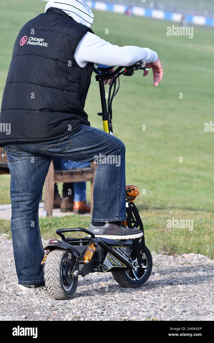 Un homme prenant une pause de la conduite de son e-scooter Banque D'Images