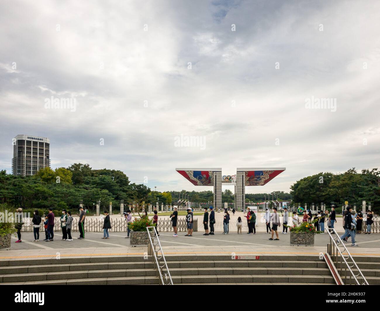 Séoul, Corée du Sud - les gens attendent en file d'attente pour le test PCR du coronavirus devant la porte de la paix mondiale, la porte principale du Parc olympique. Banque D'Images