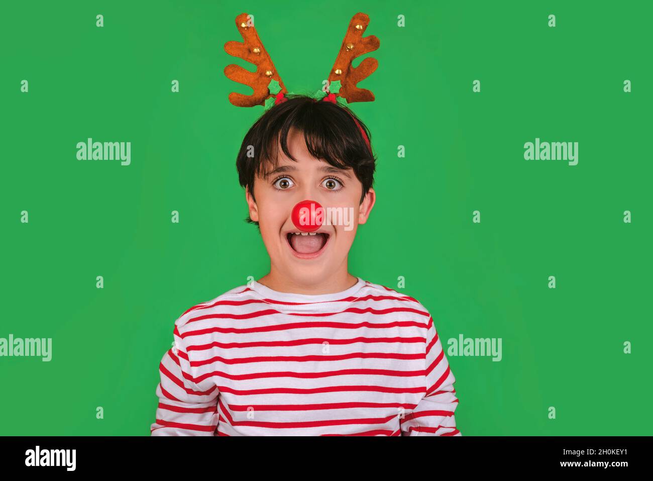 Joyeux Noël.drôle enfant dans un costume de noël de renne de Rudolph sur fond vert Banque D'Images