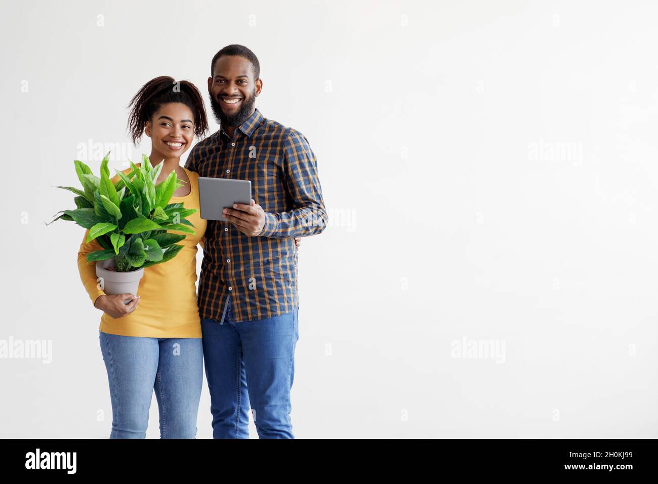 Souriant couple afro-américain millénaire porte des choses, plan dans nouvel intérieur d'appartement, isolé sur fond blanc Banque D'Images