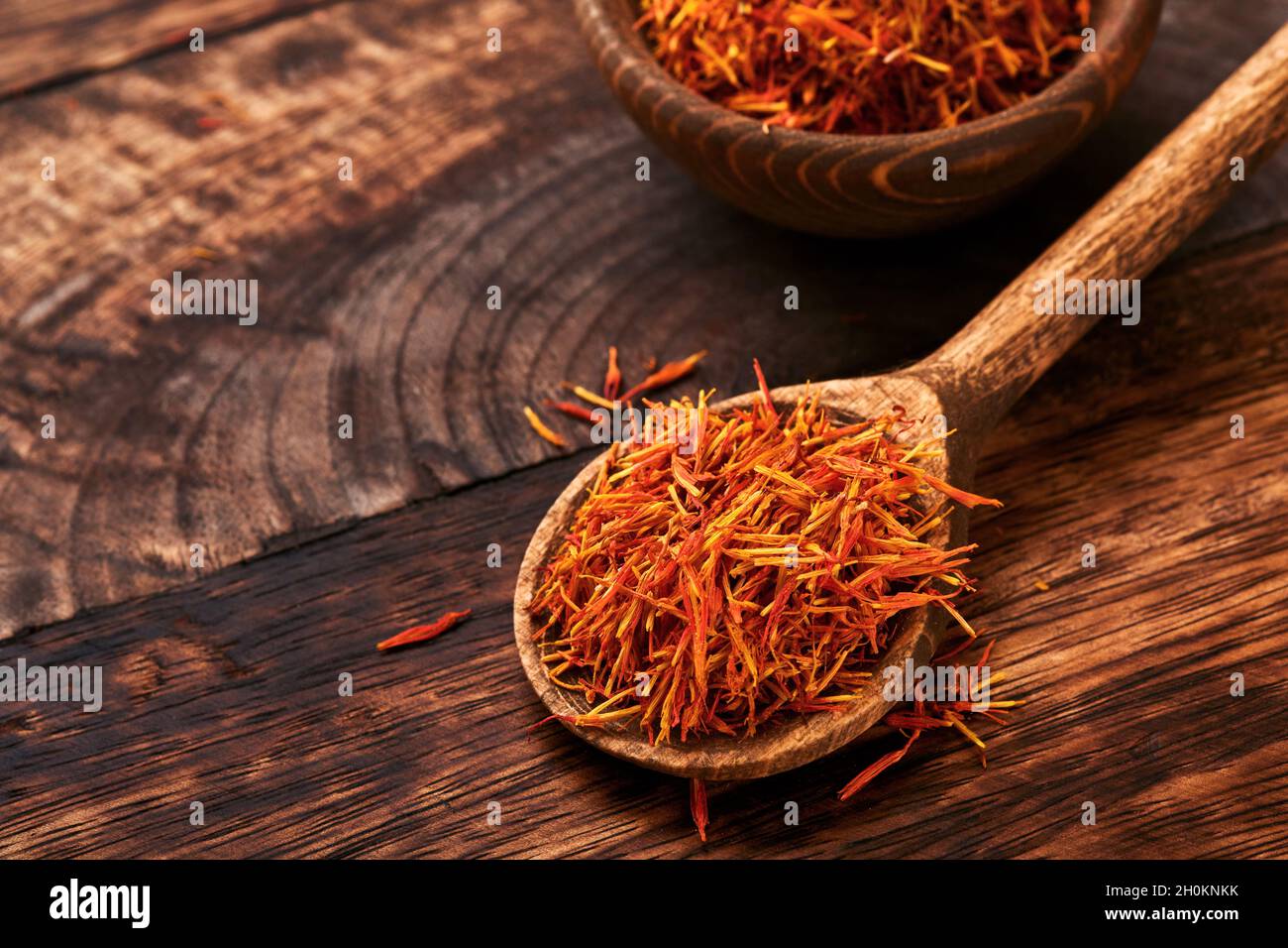 Saffron rouge en cuillère sur fond de bois ancien.Arrière-plan et texture.Maquette. Banque D'Images