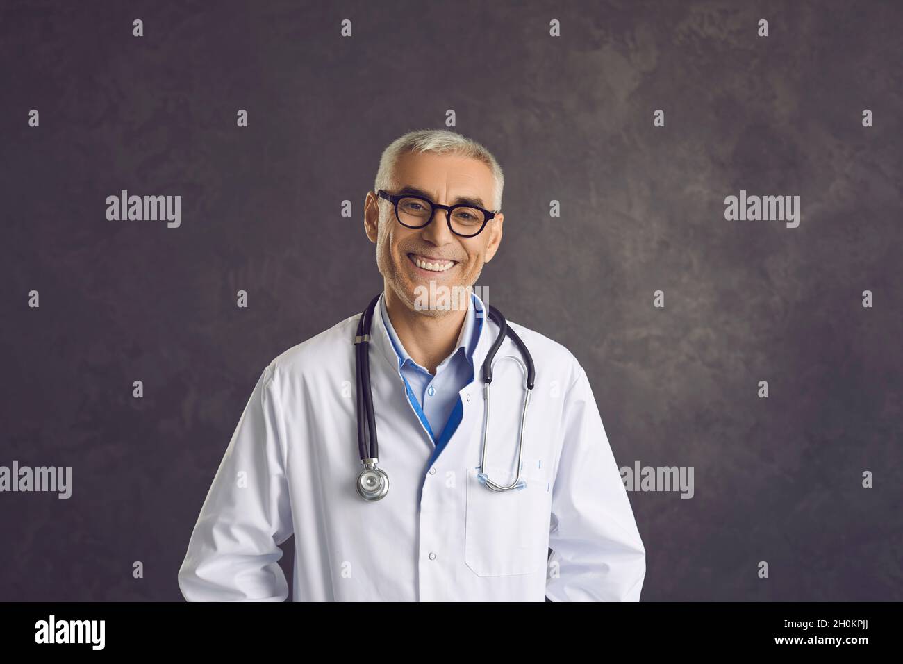 Portrait d'un homme d'âge moyen souriant médecin en uniforme blanc Banque D'Images