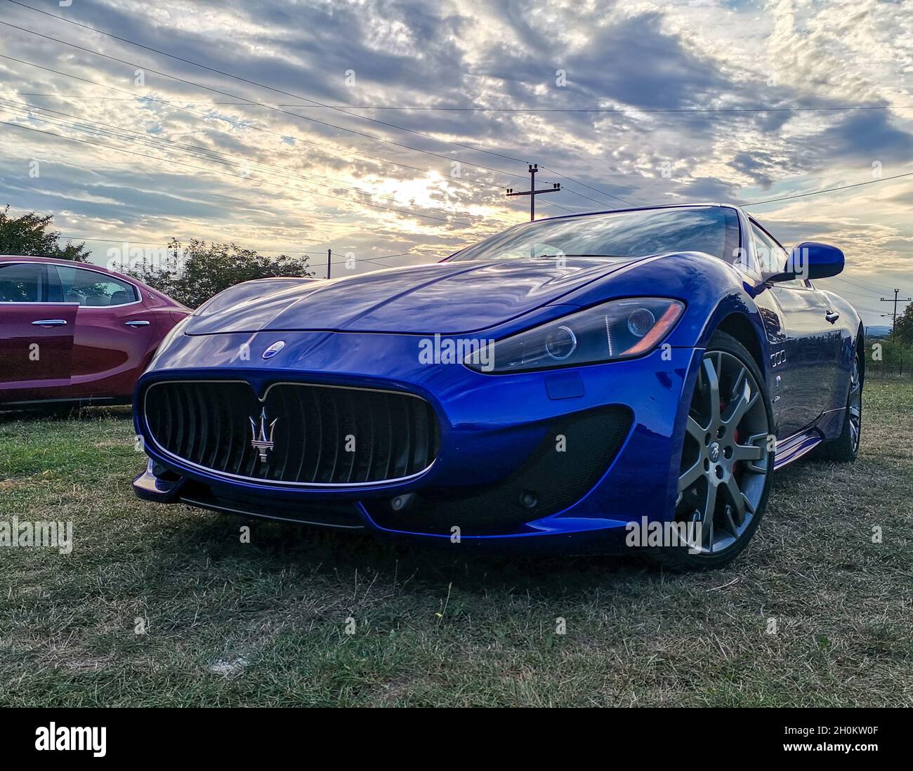 BELGRADE, SERBIE - 19 septembre 2021 : une photo d'une belle voiture Maserati bleue dans un coucher de soleil spectaculaire en arrière-plan à Belgrade, Serbie Banque D'Images